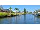 Waterfront view of canal with private boat docks with tropical landscaping in a residential neighborhood on a sunny day at 104 Inlets Blvd # 104, Nokomis, FL 34275