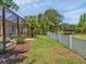 The backyard has a well-maintained lawn, white picket fence, and a screened-in porch at 13811 Nighthawk Ter, Lakewood Ranch, FL 34202