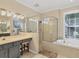 Bright bathroom featuring a double vanity, large shower, and soaking tub at 13811 Nighthawk Ter, Lakewood Ranch, FL 34202