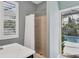 Bathroom featuring a tiled shower with a curtain and a view of the outdoor pool area at 13811 Nighthawk Ter, Lakewood Ranch, FL 34202