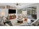 Open living room with hardwood floors, comfortable seating, and a view of the pool through sliding glass doors at 13811 Nighthawk Ter, Lakewood Ranch, FL 34202
