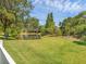The backyard is a serene view of a pond surrounded by lush trees and a well-kept lawn at 13811 Nighthawk Ter, Lakewood Ranch, FL 34202