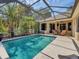 The screened-in pool is complemented by an outdoor seating area and tropical landscaping at 13811 Nighthawk Ter, Lakewood Ranch, FL 34202
