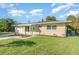 Inviting single-story home featuring a well-manicured lawn, professional landscaping, and a convenient attached garage at 145 Glenholm Ave, Punta Gorda, FL 33950