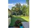 Green backyard featuring manicured lawn, lush landscaping, and a tranquil pond view at 15207 17Th E Ave, Bradenton, FL 34212