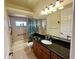 Bathroom featuring a granite countertop, wood cabinetry, a shower-tub combo, and large mirror at 15207 17Th E Ave, Bradenton, FL 34212