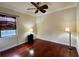 This bedroom features a ceiling fan, a large window, and hardwood floors at 15207 17Th E Ave, Bradenton, FL 34212