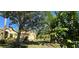 Exterior showcasing a charming home with mature trees, lush foliage, and a well-manicured lawn at 15207 17Th E Ave, Bradenton, FL 34212