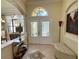 Welcoming foyer showcasing a decorative rug, bench seating, and a glass double-door entrance at 15207 17Th E Ave, Bradenton, FL 34212