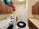 Functional laundry room features cabinets, sink, washer, and dryer for convenient chore management at 15207 17Th E Ave, Bradenton, FL 34212