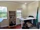Bright office space with natural light, offering a functional workspace with a bookcase and backyard views at 15207 17Th E Ave, Bradenton, FL 34212