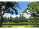 Scenic view of the pond surrounded by lush green trees and foliage under a sunny, partly cloudy sky at 15207 17Th E Ave, Bradenton, FL 34212