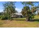 Lush backyard showcases a charming house with a screened-in porch, framed by mature palm trees at 276 Cerromar Way # 60, Venice, FL 34293