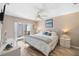 Comfortable bedroom with a white bed, ceiling fan, and sliding glass doors to the outside at 276 Cerromar Way # 60, Venice, FL 34293