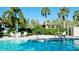 Beautiful pool area with lounge chairs, umbrellas, and lush tropical landscaping at 3500 El Conquistador Pkwy # 336, Bradenton, FL 34210