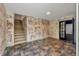 Spacious basement area with painted brick walls, tile flooring, and staircase at 3651 Walden Pond Dr, Sarasota, FL 34240
