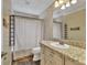 Cozy bathroom with rustic vanity, tiled countertop, and shower with curtain at 3651 Walden Pond Dr, Sarasota, FL 34240
