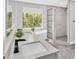 Stylish bathroom with double vanity, soaking tub by window, and a shower with black framed glass enclosure at 3651 Walden Pond Dr, Sarasota, FL 34240