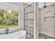 Bathroom with a soaking tub near a window and glass shower enclosure featuring white marble styled tiling at 3651 Walden Pond Dr, Sarasota, FL 34240
