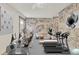Home gym featuring treadmills, stationary bikes, a brick wall and a neutral floor at 3651 Walden Pond Dr, Sarasota, FL 34240