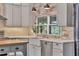 Well-appointed kitchen featuring a farmhouse sink, stainless steel appliances, and tiled backsplash at 3651 Walden Pond Dr, Sarasota, FL 34240