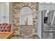 Bright kitchen featuring a brick archway, stainless steel appliances, and tiled floors at 3651 Walden Pond Dr, Sarasota, FL 34240