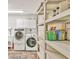 Well-organized laundry room features a washer, dryer, storage cabinets, and shelving for efficient home management at 3651 Walden Pond Dr, Sarasota, FL 34240