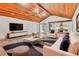 Open living room featuring a wood plank ceiling, white couches and dark rug at 3651 Walden Pond Dr, Sarasota, FL 34240