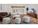 Bright living room featuring two neutral ottomans, a dark sofa, and doors to the pool at 3651 Walden Pond Dr, Sarasota, FL 34240