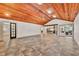 Spacious area with wood ceiling, brick fireplace, and tile floors open to kitchen at 3651 Walden Pond Dr, Sarasota, FL 34240