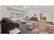 Living room featuring a dark sofa, neutral ottomans, and doors leading to the pool at 3651 Walden Pond Dr, Sarasota, FL 34240
