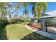 Spacious backyard with lush green grass, mature trees, and a winding sidewalk at 3951 Palau Dr, Sarasota, FL 34241