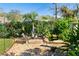 Backyard with pond, rock fire pit, mature trees, and lush landscaping at 3951 Palau Dr, Sarasota, FL 34241
