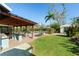 Landscaped backyard with a covered patio, outdoor kitchen, and inviting swimming pool at 3951 Palau Dr, Sarasota, FL 34241