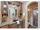 Bathroom with granite counters, wood cabinets and arched walk-in shower at 3951 Palau Dr, Sarasota, FL 34241