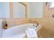 Bathroom with jacuzzi tub, stone surround, and decorative tile flooring at 3951 Palau Dr, Sarasota, FL 34241