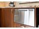 Stainless steel Fisher & Paykel dishwasher surrounded by cherry cabinets and stone countertops at 3951 Palau Dr, Sarasota, FL 34241