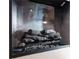 Modern fireplace with glass enclosure, featuring a gray interior and decorative logs at 3951 Palau Dr, Sarasota, FL 34241