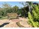 Serene garden with stone accents, a wooden bench, and lush greenery creating a tranquil outdoor space at 3951 Palau Dr, Sarasota, FL 34241