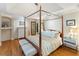 Comfortable main bedroom featuring a four-poster bed, hardwood floors, and ample natural light at 3951 Palau Dr, Sarasota, FL 34241