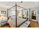 Elegant main bedroom with four-poster bed, hardwood floors, and ensuite bathroom at 3951 Palau Dr, Sarasota, FL 34241