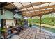 Charming outdoor living space with stone-tile flooring, a wooden pergola, and a potting table at 3951 Palau Dr, Sarasota, FL 34241