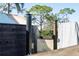 A black, modern outdoor shower with running water and privacy screen is located among trees at 3951 Palau Dr, Sarasota, FL 34241