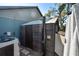 A functional outdoor shower made of wood with an adjustable showerhead on a stone surface at 3951 Palau Dr, Sarasota, FL 34241