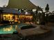 A luxurious pool and spa is surrounded by lush tropical plants and string lights for a relaxing outdoor ambiance at 3951 Palau Dr, Sarasota, FL 34241