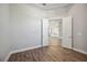 Empty bedroom showing wood floors, a view of the kitchen, and a door at 4744 Benito Ct, Lakewood Ranch, FL 34211