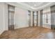 Spacious primary bedroom features tray ceiling, wood floors, and large windows with elegant draperies at 4744 Benito Ct, Lakewood Ranch, FL 34211