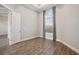 Empty bedroom showing wood floors, a window with blinds, and a door at 4744 Benito Ct, Lakewood Ranch, FL 34211