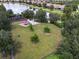 Aerial view of a community playground area with lush green trees surrounding the area and a lake in the distance at 4744 Benito Ct, Lakewood Ranch, FL 34211