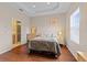 Comfortable main bedroom featuring hardwood floors, tray ceiling, and access to ensuite at 5684 Duval St, Bradenton, FL 34203